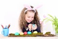 Happy easter girl in bunny ears with pencils, eggs, flowers Royalty Free Stock Photo