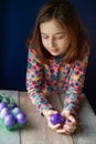 Happy easter. Girl and colored eggs in purple. Traditions of Easter. Teenager, girl 9 years old. Girl with a quack