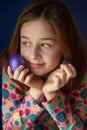 Happy easter. Girl and colored eggs in purple. Traditions of Easter. Teenager, girl 9 years old. Girl with a quack