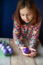 Happy easter. Girl and colored eggs in purple. Traditions of Easter. Teenager, girl 9 years old. Girl with a quack