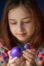 Happy easter. Girl and colored eggs in purple. Traditions of Easter. Teenager, girl 9 years old. Girl with a quack