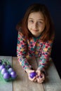 Happy easter. Girl and colored eggs in purple. Traditions of Easter. Teenager, girl 9 years old. Girl with a quack