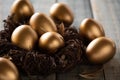 Happy easter! golden of Easter eggs in nest and Feather on wooden background