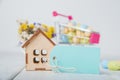 Happy Easter greeting card. Miniature wooden house. Rabbits, colorful eggs, spring flowers with tag for text Royalty Free Stock Photo