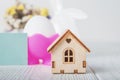 Happy Easter greeting card. Miniature wooden house. Rabbits, colorful eggs, spring flowers with tag for text Royalty Free Stock Photo