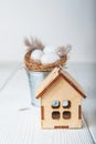 Happy Easter greeting card. Miniature wooden house. Rabbits, colorful eggs, spring flowers with tag for text Royalty Free Stock Photo