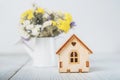 Happy Easter greeting card. Miniature wooden house. Rabbits, colorful eggs, spring flowers with tag for text.. Royalty Free Stock Photo