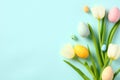 Happy Easter greeting card template. Bouquet of tulips and Easter eggs on pastel blue background Royalty Free Stock Photo