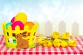 Happy Easter Greeting Card Template. Colorful Easter Eggs In A Basket With A Bouquet Of Yellow Tulips On Picnic Tablecloth Over