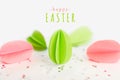 Happy Easter greeting card with text and handmade paper green and pink eggs against of silver stars on white background. DIY, Royalty Free Stock Photo