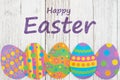 Happy Easter greeting with Easter egg on weathered wood