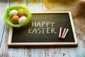Happy Easter holiday composition with Easter eggs in nest on blue background. Top view, flat lay Royalty Free Stock Photo