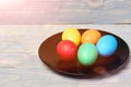 Painted easter eggs on black plate on wooden background Royalty Free Stock Photo