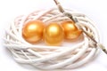 Traditional eggs painted in golden color inside woven wooden wreath Royalty Free Stock Photo