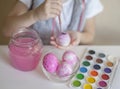 Happy easter. Little girl painter in pink bunny ears with colorful painted eggs. A kid preparing for Easter. Painted hand Royalty Free Stock Photo