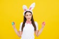 Happy Easter. Portrait of young smiling woman with bunny ears isolated on yellow studio background. Easter bunny woman Royalty Free Stock Photo