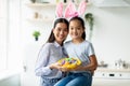 Happy Easter. Pretty asian girl and woman wearing rabbit bunny ears and holding basket full of painted egg Royalty Free Stock Photo