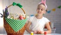 Happy Easter sign on basket, pretty girl looking at big basket full of dyed eggs