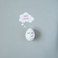 Happy Easter. Smiling easter egg with thought bubble on gray background