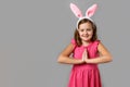 Happy easter. Smiling little girl in a pink dress with polka dots on a gray background. Royalty Free Stock Photo