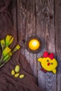 Happy Easter. Spring flowers yellow daffodils, easter eggs, candle and gingerbread chicken on a wooden background. Top view Royalty Free Stock Photo