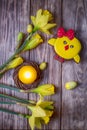 Happy Easter. Spring flowers yellow daffodils, easter eggs, candle and gingerbread chicken on a wooden background. Top view Royalty Free Stock Photo