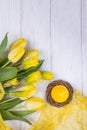 Happy Easter. Spring flowers yellow daffodils and tulips, easter eggs and candle on a white background. Top view, free space Royalty Free Stock Photo