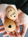 Happy Easter or st valentines morning before breakfast. Young couple holding eggs with declaration of love. Art on eggs