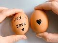 Happy Easter or st valentines morning before breakfast. Young couple holding eggs with declaration of love. Art on eggs