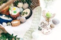 Happy Easter. Stylish Easter eggs, easter bread cake, ham, beets, sausage, butter, green branches in wicker basket on white wooden Royalty Free Stock Photo