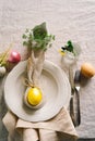 Happy Easter. Stylish easter eggs on a napkin with spring flowers on white wooden background