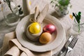 Happy Easter. Stylish easter eggs on a napkin with spring flowers on white wooden background