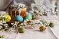 Happy Easter! Stylish natural dyed easter eggs on background of homemade easter bread with spring flowers on plate on table.