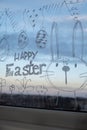 HAPPY EASTER text on creative painted window with white marker. Easter bunny rabbit decoration on big clear window Royalty Free Stock Photo