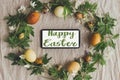 Happy Easter text on phone screen in easter rustic wreath with eggs and flowers, flat lay, handwritten sign. Beautiful stylish Royalty Free Stock Photo