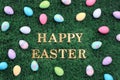 Happy Easter text surrounded with colorful Easter eggs on grass Royalty Free Stock Photo