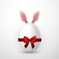 Happy Easter. Vector realistic Easter egg with red bow and Easter Bunny ears, isolated on a gray background Royalty Free Stock Photo