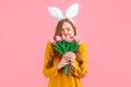 Happy Easter. Happy woman in Easter Bunny ears, girl with a bouquet of tulips, on an isolated pink background Royalty Free Stock Photo