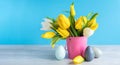 Happy Easter. Wooden decorative eggs and bouquet of yellow tulips in bucket on blue background. Concept: beautiful greeting easter Royalty Free Stock Photo