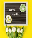 Easter bunny eggs, flowers on yellow background. Copy space, top view. Flat lay of Easter celebration concept Royalty Free Stock Photo