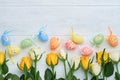 Happy Easter. Yellow and white roses and colored eggs on white wooden background. Easter background with copy space. Floral Royalty Free Stock Photo