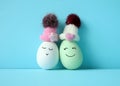 Happy eggs in hats laughing. Easter holiday concept with cute eggs with funny faces. Royalty Free Stock Photo