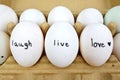 Happy eggs written live laugh, love. Quote sentences for inspiration and mindfulness spiritual living lifestyle in minimal Royalty Free Stock Photo