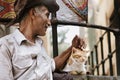 Happy Egyptian old man with a hat fondling on a Cat outdoors