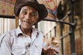 Happy Egyptian old man with a hat looking at the camera next to a Cat