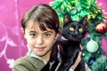 Happy eight year old girl with black cat for Christmas gift Royalty Free Stock Photo