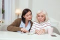 Happy elder woman and caregiver collecting puzzle Royalty Free Stock Photo