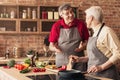 Happy elderly couple cooking healthy lunch together at home kitchen Royalty Free Stock Photo