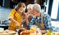 Happy senior couple having breakfast with their grandchildren at home