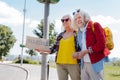 Happy elderly couple hitchhiking